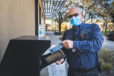 Man wearing surgical mask submitting self-covid test