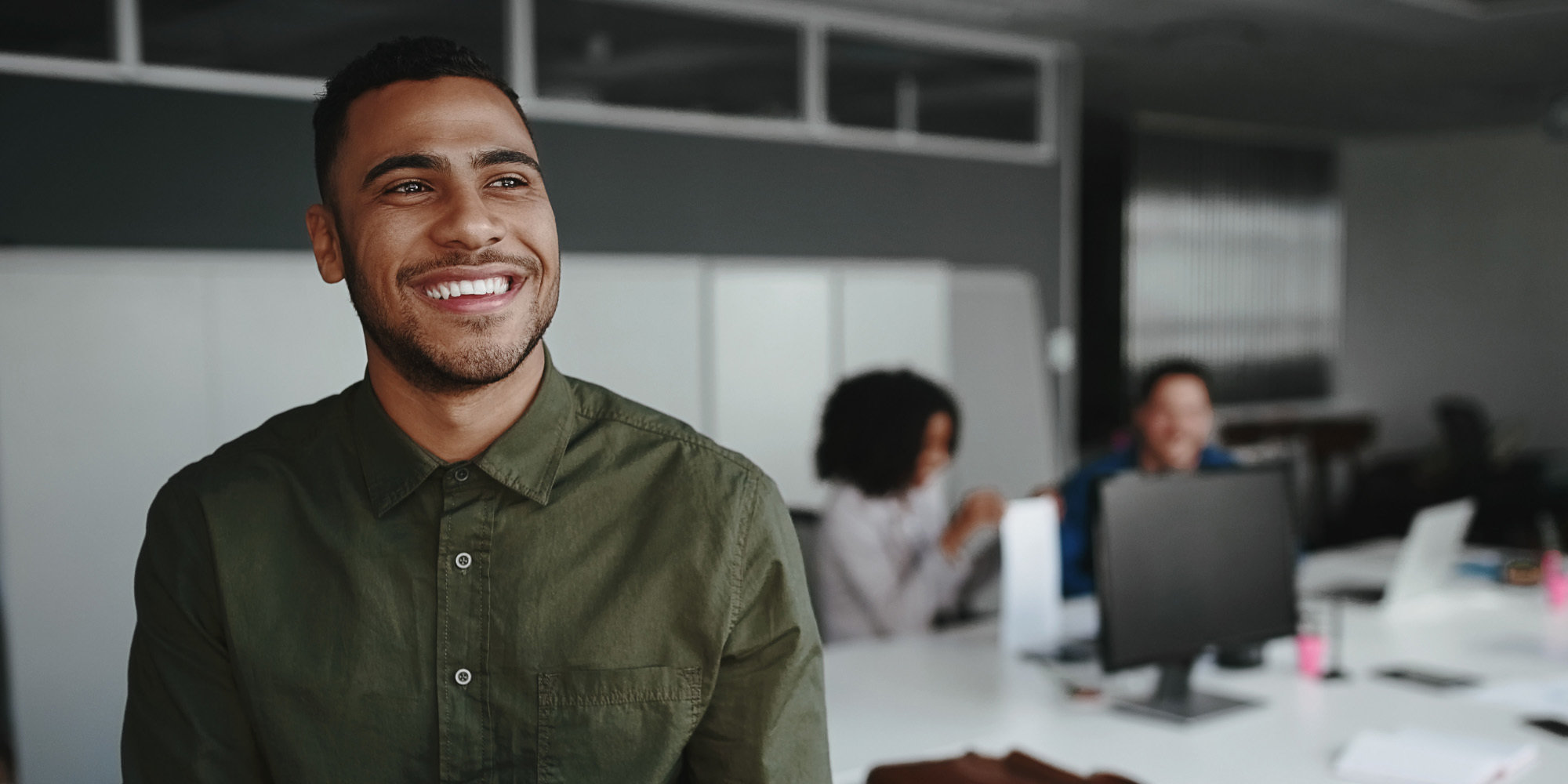 Portrait of a young creative business owner holding digital tablet in hand smiling and looking away