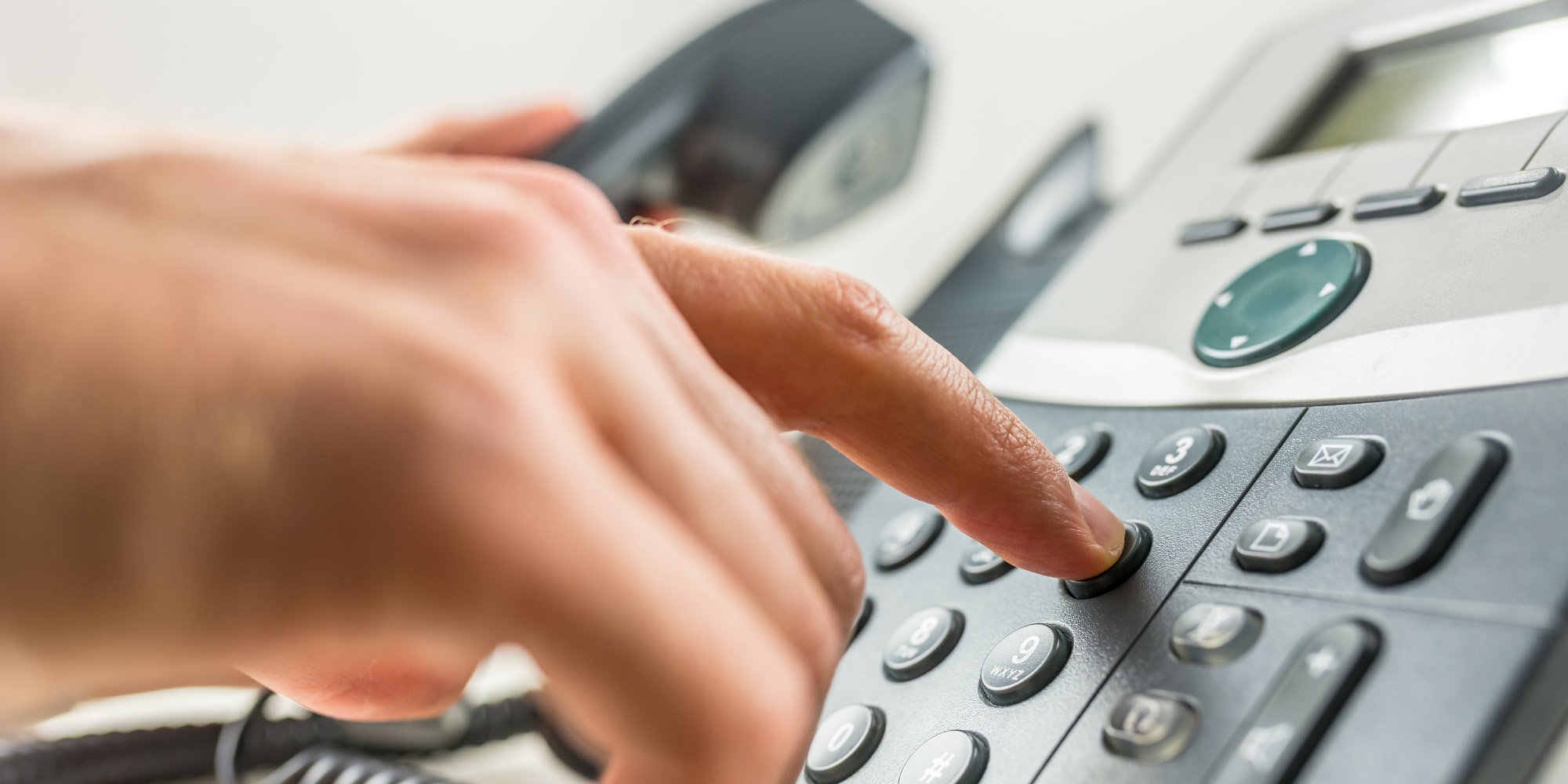 Close up of person using a phone dial pad