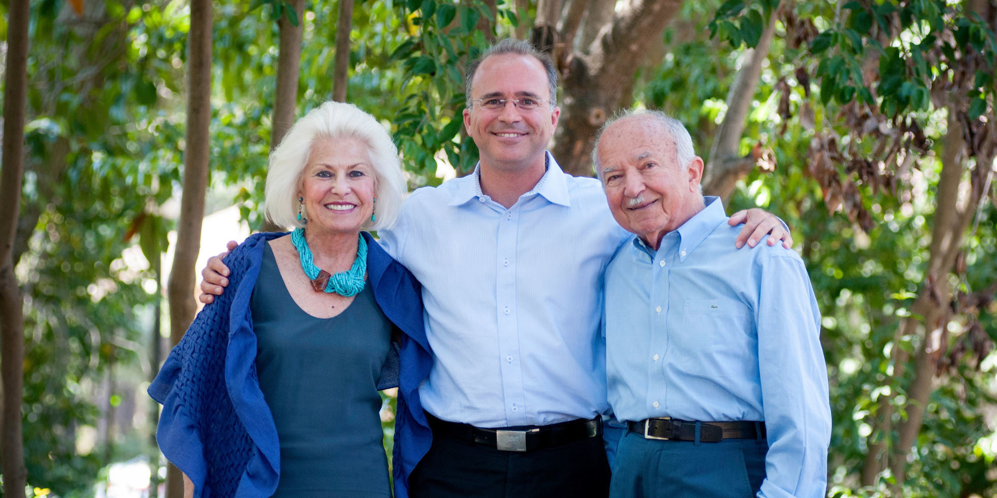 Man holding arms around his senior parents 